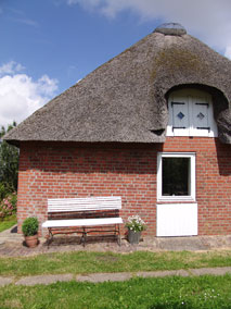 Haus mit Bank und Reetdach - (C) www.ferienhaus-nordriesland.com